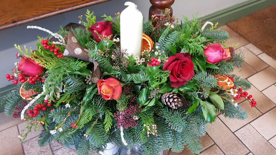 Oval christmas candle table center with red roses and berries