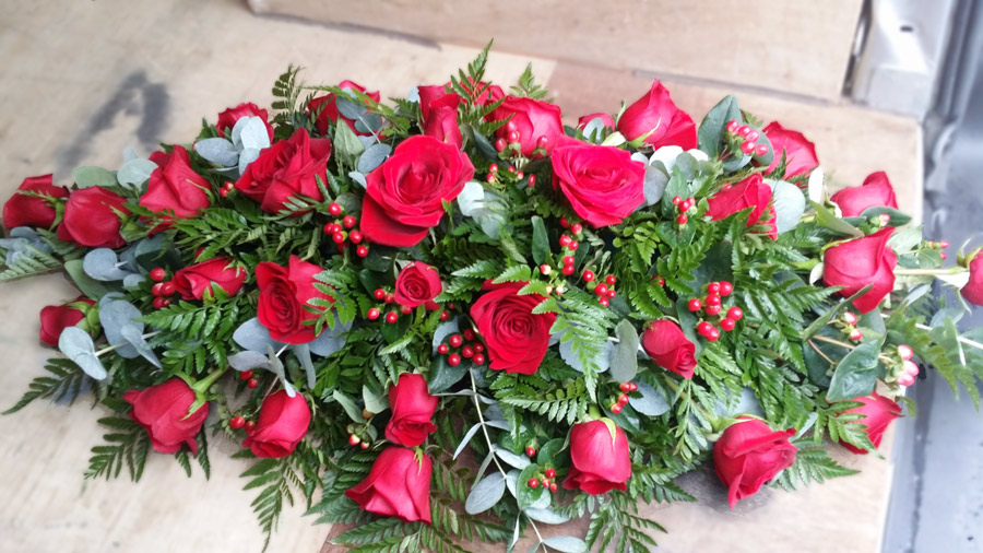 Red rose and berries casket spray