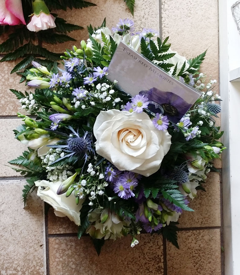 Small posy in a dish - white roses, freesias, asters and thistles